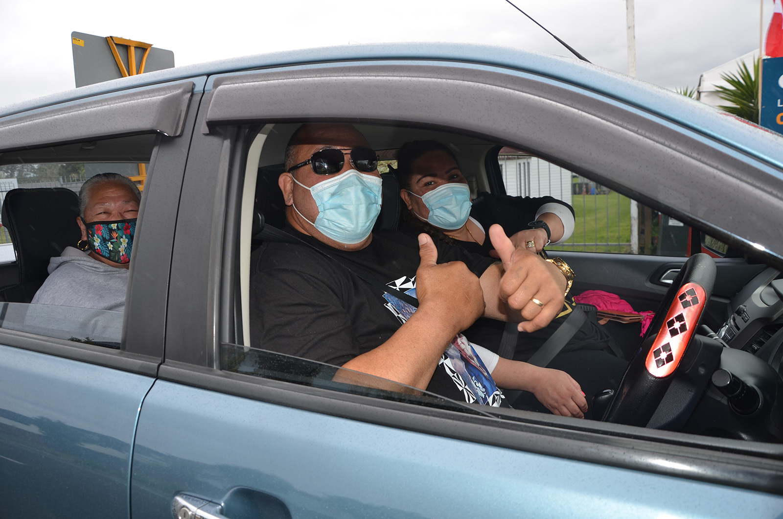 People wearing masks in a car